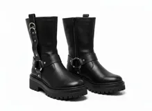 Botas de caña media en cuero negro, con suela track dentada y taco cuadrado. Presentan un diseño con correas ajustables, argollas metálicas y detalles de tachas plateadas.