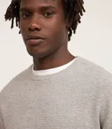 Suéter negro de tejido de punto maquinetado con cuello redondo y manga larga.