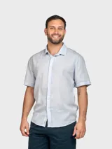 Camisa de lino color beige, de manga corta, con cuello clásico y cierre frontal con botones.