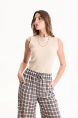 Musculosa de rib de algodón color blanco, con calce ajustado, escote redondo alto y sin mangas.