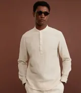 Camisa de manga larga con cuello padre y cierre frontal parcial con botones. Presenta un corte amplio y cómodo, confeccionada en una mezcla de lino y algodón.