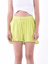 Short de color verde lima con cintura elástica, cordón ajustable y detalle de volado en el ruedo.