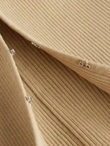 Cárdigan cropped de punto de canalé color beige, con cierre de corchete, mangas largas y logo bordado de Calvin Klein en el bajo.