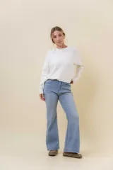 Jean wide leg de tiro alto con pierna amplia, confeccionado en denim con leve desgaste. Presenta cintura con presillas, bolsillos clásicos y cierre frontal con botón.