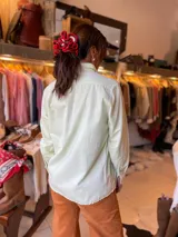Camisa blanca de manga larga, de corte clásico y holgado, confeccionada en algodón con botones de madera.