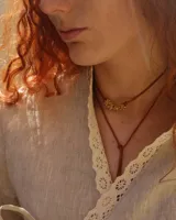 Collar corbatero con hilo de algodón natural color suela y dije de bronce macizo con forma de flores.