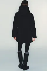 Chaqueta acolchada de color negro, resistente al agua y al viento, con aislamiento térmico. Presenta cuello subido con capucha, cierre frontal con cremallera termosellada de doble cursor, bolsillos laterales con forro polar y puños interiores elásticos.