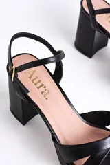 Sandalias negras de cuero sintético con plataforma y tacón cuadrado. Presentan tiras cruzadas en el empeine y pulsera con hebilla al tobillo.