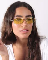 Lentes de sol rectangulares con marco plateado y cristales amarillos.