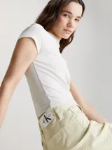 Shorts color crema de sarga de algodón elástica, talle alto, con bragueta con cremallera, diseño de cinco bolsillos, acabado ligeramente lavado y herrajes de Calvin Klein.