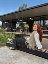 Chaleco tejido a mano color beige con cuello alto y flecos en el ruedo. Hecho por encargo en lana.