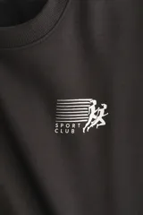 Buzo de corte oversized con interior cepillado, cuello redondo, hombros caídos y puños acanalados. Presenta un diseño estampado en el pecho con la inscripción Sport Club.