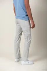 Pantalón de gabardina color beige, de corte recto, con cinco bolsillos y detalle de bordado de un pájaro en el bolsillo delantero.