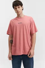 Remera de manga corta color salmón, con fit regular y escote redondo. Presenta un estampado frontal con la palabra "MISTRAL" en negro.