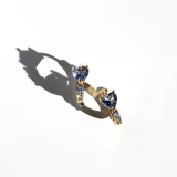 Par de aros tipo argolla con bisagra, con cristales engarzados y cristal en forma de corazón color azulino. Acabado en oro 18k.