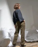 Pantalón verde militar tornasolado de algodón brillante, corte a la cintura y piernas rectas con textura de tableado central.