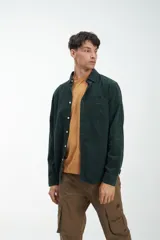 Camisa de manga larga azul de pana fina 100% algodón, con bolsillo en el pecho, botones blancos y calce clásico.