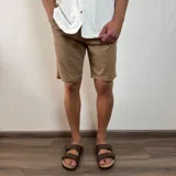 Bermuda de gabardina color marrón claro, corte recto, con bolsillos laterales y traseros.