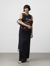 Bolso tipo bowling de Adolfo Dominguez, color borgoña oscuro con acabado brillante y textura craquelada. Posee asas de mano negras y un cordón ajustable lateral.