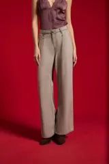 Pantalón jean gris de tiro alto, con pinzas frontales, bolsillos y diseño de pernera ancha.