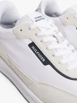 Zapatillas Tommy Hilfiger de running, color blanco con detalles en beige y burdeos. Confeccionadas en ante, poliéster y goma, con suela dentada de EVA y logo distintivo de la marca en el lateral y el talón.