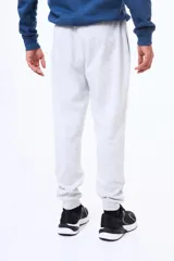 Pantalón de felpa con cintura elástica ajustable mediante cordón, bolsillos laterales y puños acanalados en los tobillos.