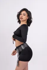 Minifalda negra ajustada al cuerpo con cinturón de cuero sintético con apliques metálicos.