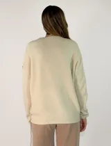 Sweater de punto gris con cuello en V, manga larga y detalles de costuras decorativas en color negro a lo largo del centro y en las mangas.