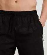 Bermuda deportiva de hombre color marrón, con cintura elástica ajustable mediante lazo y estampa heat print. Confeccionada en tejido de poliéster de secado rápido, diseñada para brindar comodidad y libertad de movimiento durante la actividad física.