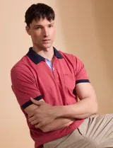 Remera manga corta color verde con cuello polo y bolsillo en el pecho. El cuello y los puños son de color azul marino.