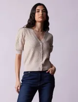 Cárdigan blanco tejido con escote en V, abertura frontal con botones y mangas cortas abullonadas con puño.