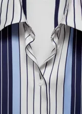 Camisa de tejido fluido con acabado satinado, diseño de rayas verticales en tonos azul marino, blanco y celeste. Presenta cuello camisero, cierre frontal con botones y mangas largas con puños abotonados.