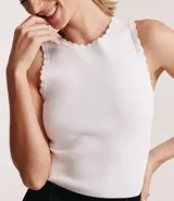 Musculosa blanca de punto con detalle de ondas en sisas y cuello.