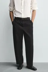 Pantalón de corte balloon fit confeccionado en una mezcla de lyocell y algodón. Presenta cierre frontal con cremallera y botón, bolsillos laterales y bolsillos traseros de vivo.