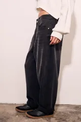 Jean de corte baggy con diseño barrel, tiro medio y acabado en color negro lavado. Presenta cierre frontal con botón y bolsillos laterales y traseros.