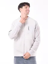 Campera gris claro de corte bomber, con cuello, puños y ruedo acanalados. Presenta cierre frontal y bolsillo en el pecho con cierre.