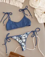 Conjunto de bikini con corpiño triangular con tiras para atar en los hombros y bombacha colaless reversible con tiras para atar en los costados.
