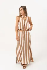 Falda larga tejida a rayas verticales color beige y blanco, con pretina elástica y tajos laterales.