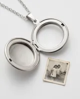 Collar con dije tipo relicario circular de acero inoxidable, diseñado para insertar fotografías en su interior.