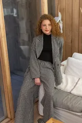 Pantalón de paño tiro alto de corte ancho y holgado, con estampado a cuadros en tonos marrones y beige.