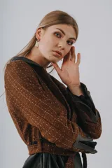 Campera tipo sobrecamisa de paño con diseño de espiga, color marrón. Presenta cierre frontal con botones, dos bolsillos superiores con solapa y mangas largas con puños abotonados.