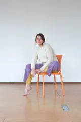 Buzo tejido a mano con manga raglán y cuello semi alto. Presenta un diseño con texturas variadas en el tejido y terminaciones onduladas en el ruedo.