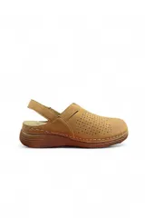 Zueco de cuero sintético color marrón, con diseño perforado en el empeine, tira trasera ajustable con velcro y suela corrida.