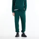 Pantalón de jogging New Balance Athletics color verde oscuro, con cintura elástica con cordón regulable, bolsillos laterales, bajo elástico y logo bordado en la pierna izquierda.