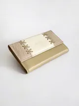 Billetera de cuero con diseño tricolor en tonos neutros, con detalle de costuras decorativas en forma de cruz en la solapa frontal y cierre con broche.