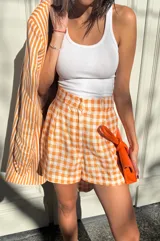 Short de lino a cuadros color naranja y blanco, estilo sastrero con calce holgado.
