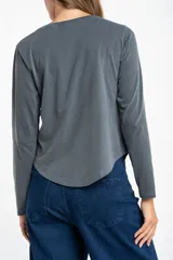 Remera de manga larga con cuello redondo, confeccionada en algodón lavado con efecto desgastado. Presenta un corte oversize y una textura suave y resistente.