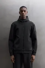 Campera canguro de Zara Athleticz, modelo relaxed fit, confeccionada en tejido técnico compacto elástico con mezcla de algodón en color azul marino. Cuenta con cuello subido con capucha, manga larga con bolsillo lateral con cierre, bolsillos frontales con cierre y acabado termofijado, cierre frontal de doble dirección y logo estampado en el bajo.