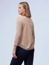 Buzo beige de tejido calado, con escote a la base y mangas tres cuartos.