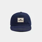 Gorro de denim azul con visera y parche con logo de la marca en el frente.